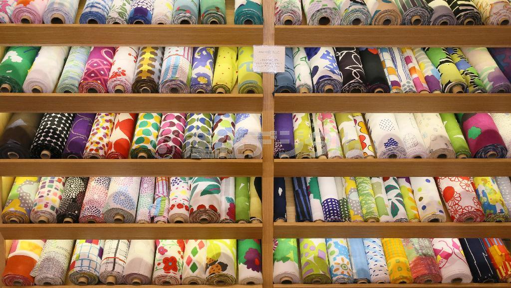 ２階の「ＳＯＵ・ＳＯＵ＿染めおり」では、壁一面にテキスタイル（布地・織物）が。これは手ぬぐいにも使われる伊勢木綿の生地「文」（３５センチ幅）で、１０センチ１１８円＝２０１５年２月１３日、京都市中京区（志儀駒貴撮影）