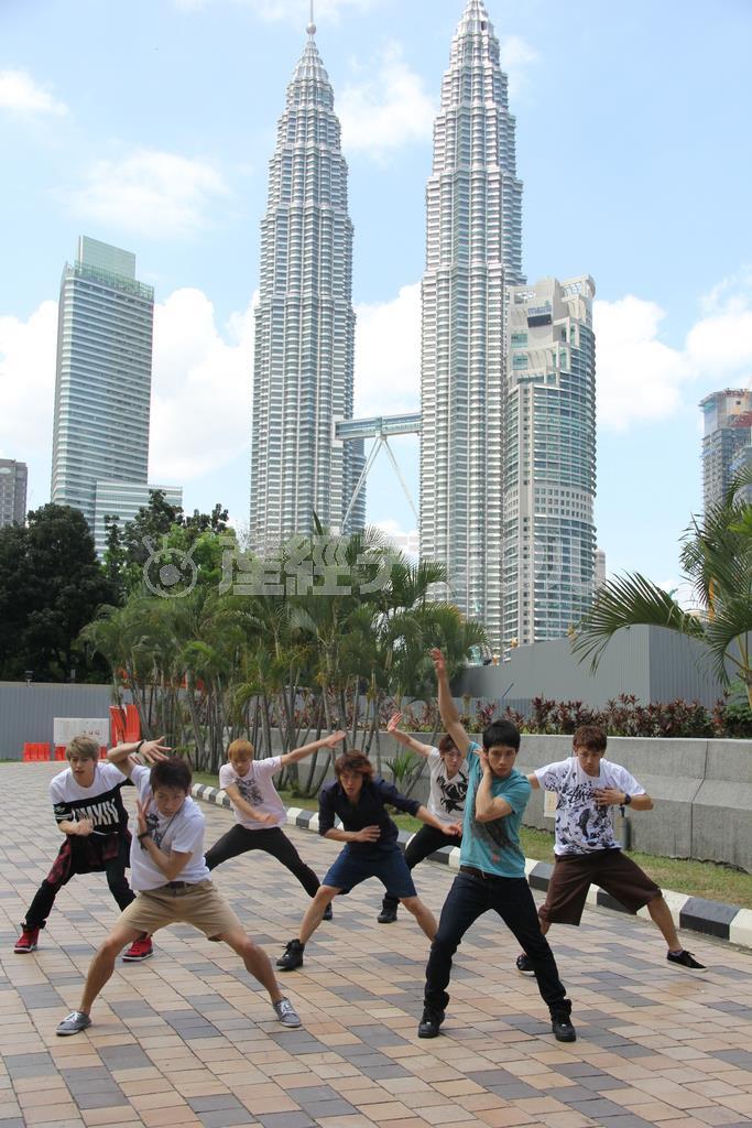 首都クアラルンプールのランドマークにもなっている「ペトロナスツインタワー」をバックに路上でダンスを踊るブルートーキョーのメンバー。ストリートダンスの原点に立ち帰った＝２０１５年２月７日、マレーシア（田中幸美撮影）