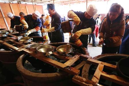 江蘇省鎮江市の老舗しょうゆ企業の臨時販売所で２月、春節（旧正月）用のしょうゆを注ぐ従業員（中国新聞社）