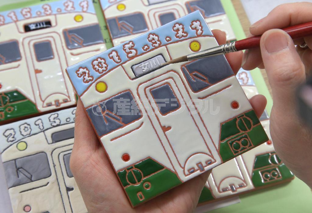 ３月２１日のＪＲ女川駅再開の時に売り出された石巻線の列車をデザインしたスペインタイル。限定５０個、木枠額入りで４０００円＝２０１５年、宮城県牡鹿郡女川町（鈴木健児撮影）