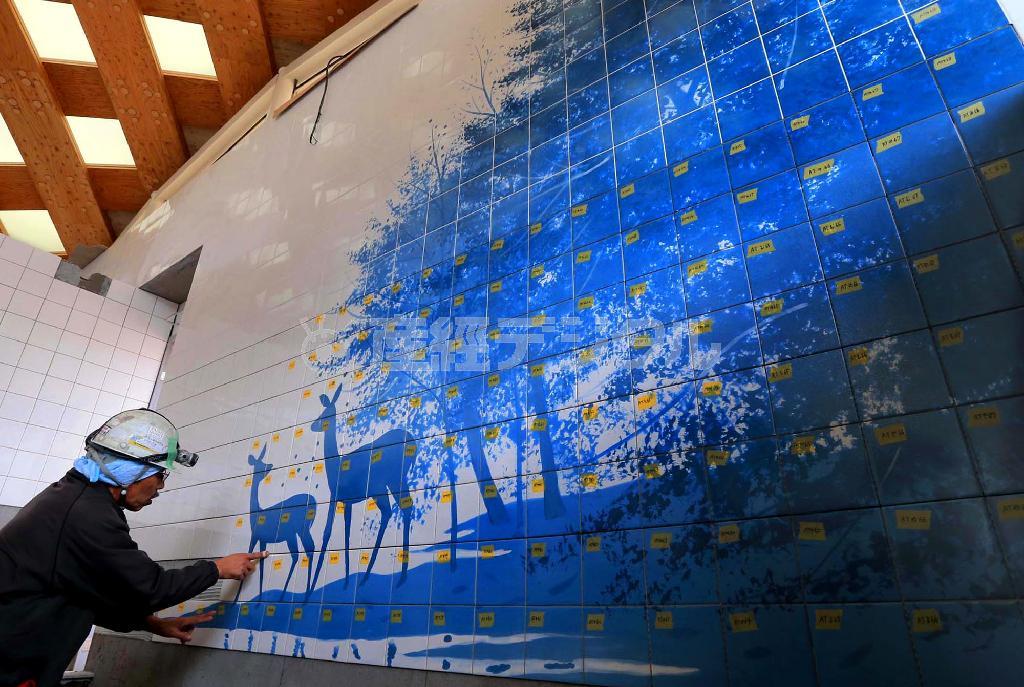 温泉施設「ゆぽっぽ」の浴室に飾られたタイル絵「泉と鹿」。日本画家の千住博氏の作品で、約６５０枚のタイルが使われている＝２０１５年２月６日、宮城県牡鹿郡女川町（鈴木健児撮影）