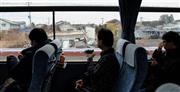 ＪＲ常磐線の竜田－原ノ町間を走る代行バス。双葉郡双葉町に入ると崩れたままの建物が目立った＝２０１５年３月１日、福島県（早坂洋祐撮影）