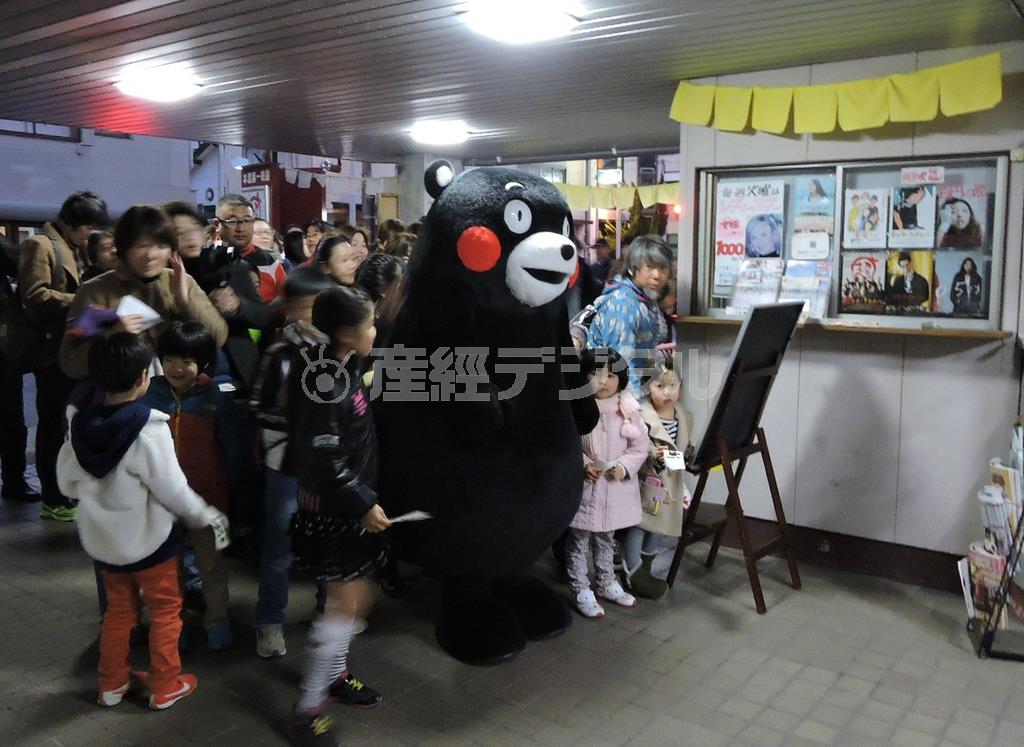 本渡第一映劇の前には、くまモンに手を引かれた子供たちを先頭に市民らの列ができた＝２０１５年２月１５日、熊本県天草市（藤沢志穂子撮影）