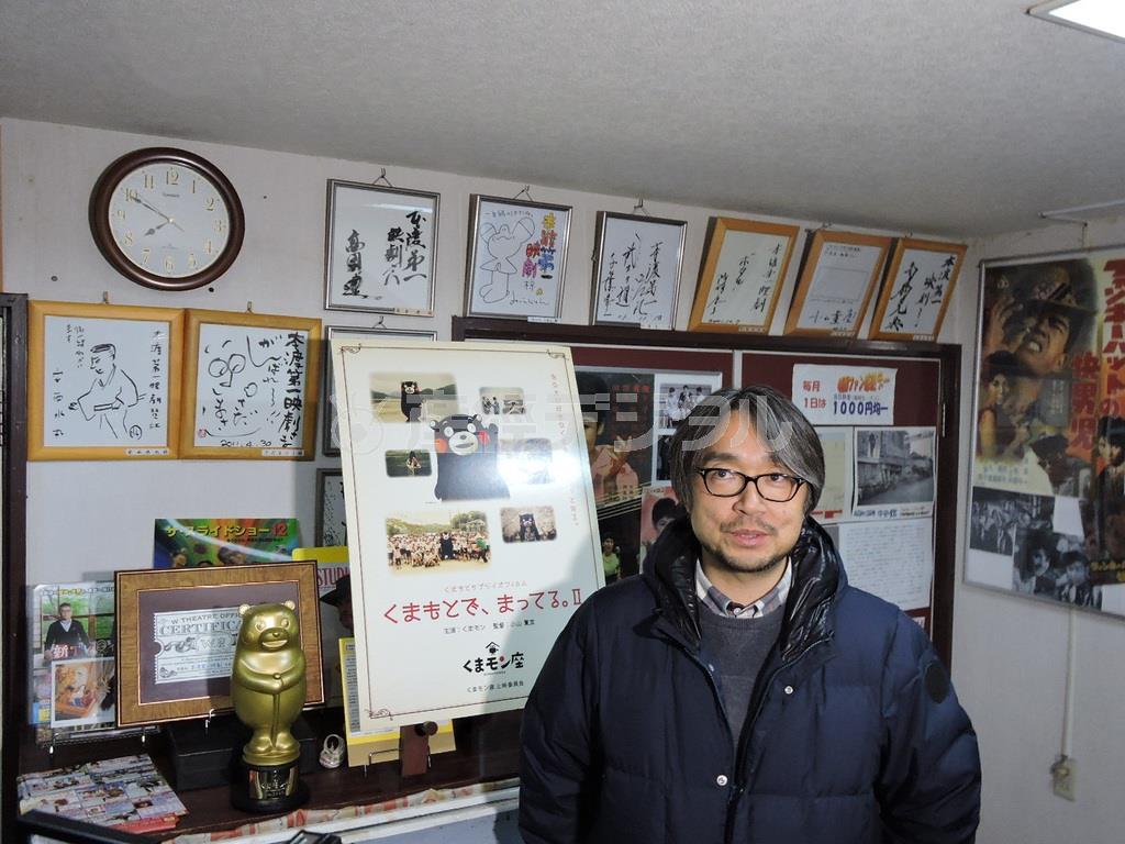 「映画館ごっこ」への思いを本渡第一映劇で、ポスターのサンプルやトロフィーをバックに話す小山薫堂（こやま・くんどう）さん。館内にはこれまで訪れた映画人たちのサインやポスターが飾られている＝２０１５年２月１５日、熊本県天草市（藤沢志穂子撮影）