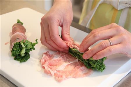 菜の花の肉巻き（作り方１）＿＿肉を広げ、塩、こしょうをふる。小麦粉を薄くふり、菜の花を３本ずつ巻く（田中幸美撮影）