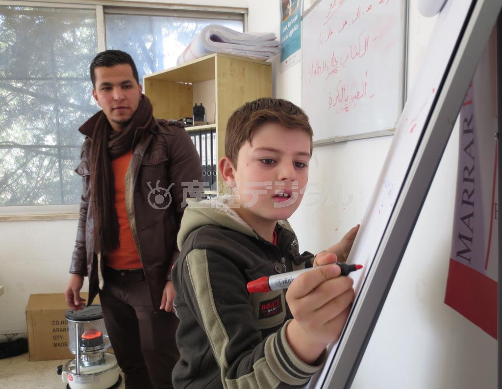 アラビア語の問題を解く男の子＝２０１５年１月２０日、ヨルダン（ワールド・ビジョン・ジャパン撮影）