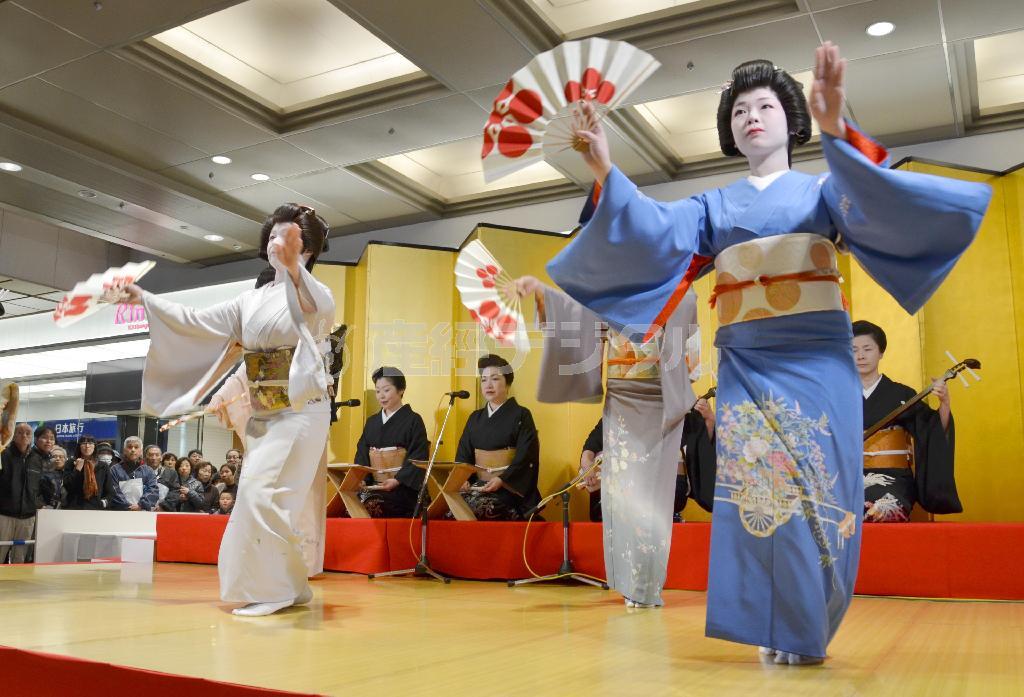 改札前に設置された舞台で、踊りを披露する芸妓＝２０１５年３月１４日午前、石川県金沢市・ＪＲ金沢駅（共同）