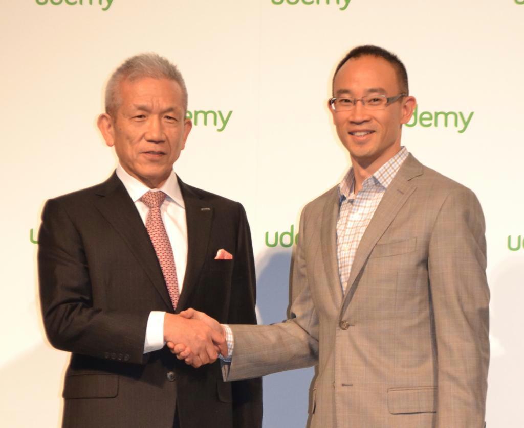 握手するベネッセＨＤの原田泳幸会長兼社長（左）と、米ユーデミーのデニス・ヤンＣＥＯ（最高経営責任者）＝東京都港区