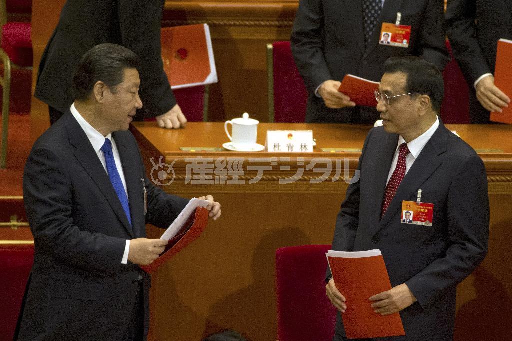 ３月１５日、全人代の閉幕直後に言葉を交わす中国の習近平国家主席（左）と李克強首相。政権のトップ２は、反腐敗運動の思わぬ副作用に頭を悩ましている＝２０１５年、中国・首都北京市西城区の人民大会堂（ＡＰ）