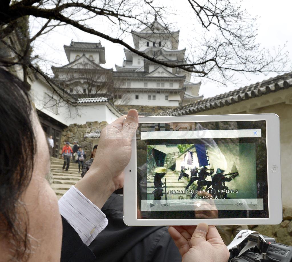 姫路城大天守前で、「拡張現実（ＡＲ）」の技術によってタブレット端末に表示された武士の映像＝２０１５年３月１８日午前、兵庫県姫路市（共同）