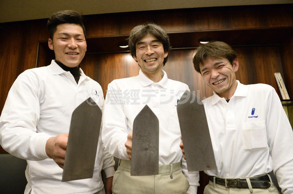 しっくい塗りに使うこてを手に、笑顔を見せる左官職人の（左から）佐藤政太さん、中田正起さん、中村圭一さん＝２０１５年２月、大阪市北区（共同）