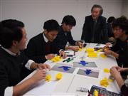 就活志塾の講師を務める西田芳明社長（最奥）とブロック玩具を組立てる学生たち＝大阪市