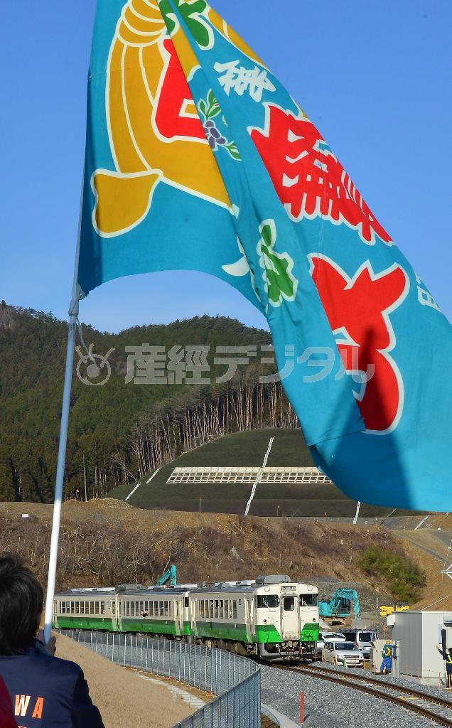 大漁旗の出迎えを受けて女川駅に入る列車＝２０１５年３月２１日、宮城県牡鹿郡女川町（大西正純撮影）