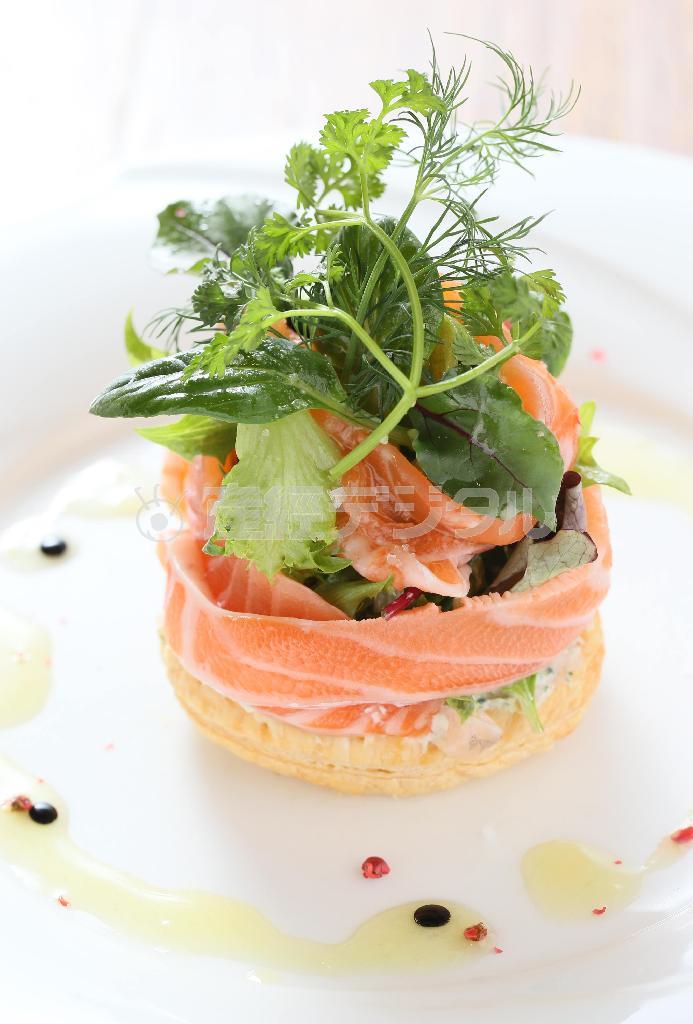 前菜の「サーモンマリネとサラダのフィユテ」。パイの上に山羊のチーズと香草エシャロット、脂ののったサーモンがぐるりと巻き付けられている。店をオープンして以来人気の一品。すべて５０００円（税込み）のコース料理より＝２０１５年３月１０日、京都市下京区（志儀駒貴撮影）