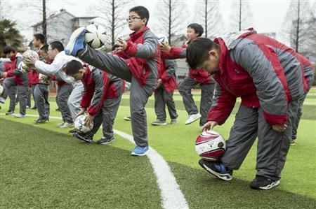 中国東部の浙江省杭州で、体育の授業中にサッカーに興じる小学生たち。中国は今後２年で２万校のサッカー学校を設立して若い優れた才能を発掘し、Ｗ杯制覇への夢に近づこうとしている＝２０１５年３月１８日（ＡＰ）
