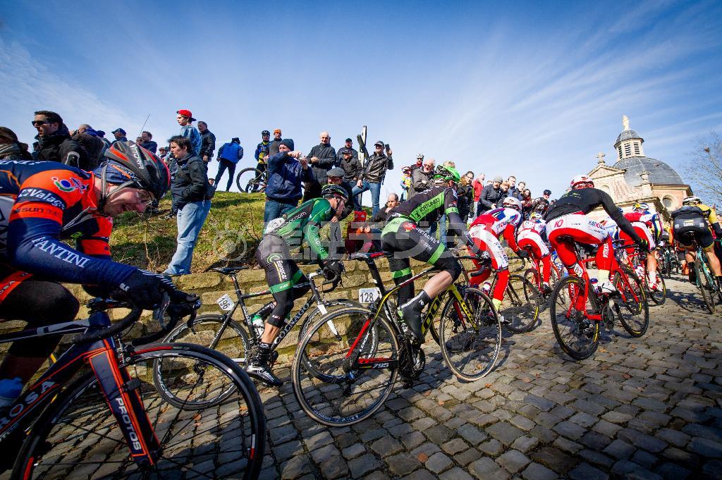 「オンループ・ヘット・ニュースブラッド」で、フランドル地方のクラシックレースの名所「カペルミュール」を駆け抜ける選手たち＝２０１５年２月２８日、ベルギー・ヘラールツベルヘン（田中苑子さん撮影）