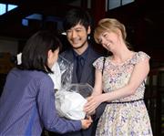 「まれ」主人公役の土屋太鳳（左）に激励の花束を渡す「マッサン」の玉山鉄二（中）とシャーロット・ケイト・フォックス（右）＝渋谷区のNHK（撮影・今野顕）