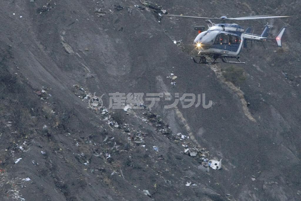 ジャーマンウイングス機の残骸が散乱するフランス南東部のアルプス山脈の墜落現場上空を飛ぶ救難ヘリコプター＝２０１５年３月２４日（ＡＰ）