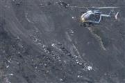 ジャーマンウイングス機の残骸が散乱するフランス南東部のアルプス山脈の墜落現場上空を飛ぶ救難ヘリコプター＝２０１５年３月２４日（ＡＰ）