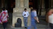インド西部ムンバイの鉄道駅構内で、スマートフォンを見つめる男性。インド最高裁は、インターネット上で誹謗中傷などをした者に刑事罰を科すことを定めた情報技術法の条項は違憲との判決を下した＝２０１５年３月２４日（ＡＰ）