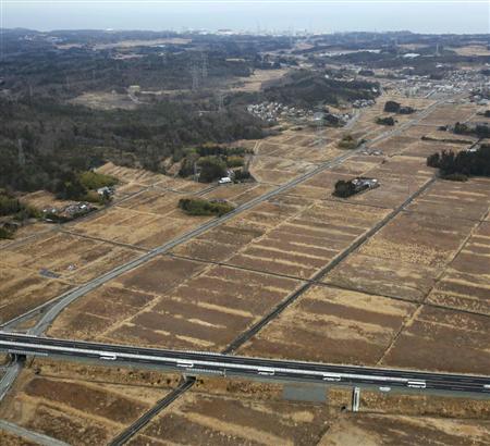 「帰還困難区域」を通る常磐自動車道の浪江－常磐富岡ＩＣ間で通り初めをする車列。３月１日に開通した。奥上には福島第１原発が見える＝１日午前、福島県大熊町