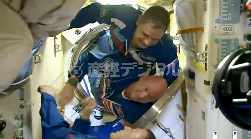 ソユーズ宇宙船から国際宇宙ステーションに入るロシアのミハイル・コルニエンコ飛行士（上）と米国のスコット・ケリー飛行士（中央）＝日本時間２０１５年３月２８日（ＮＡＳＡ提供・共同）