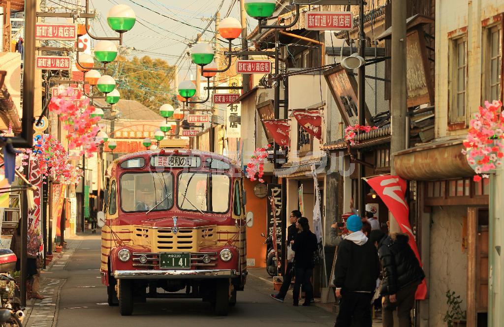 「昭和の町」の商店街を縫うように運行するボンネットバス。懐かしい町並みに花を添える＝２０１５年１月２４日、大分県豊後高田市（松本健吾撮影）