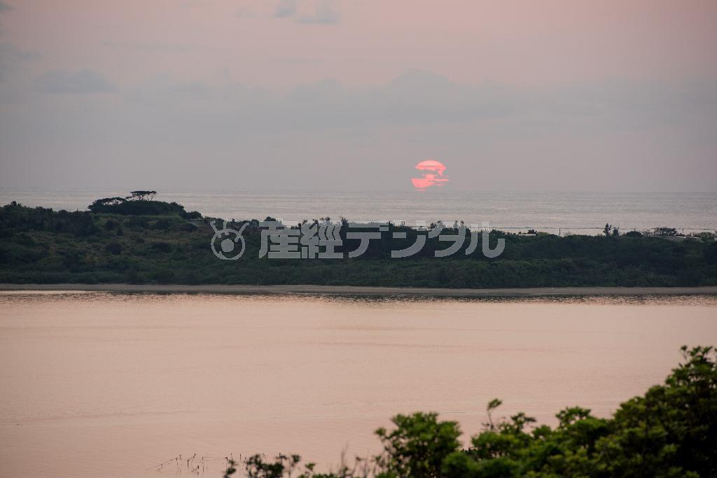 石垣島の中央に位置する伊原間地区、崖っぷちにある私の家のベランダからは林の向こうの海に朝焼けを望むことができる＝２０１５年２月１１日、沖縄県石垣市（永山真治さん撮影）