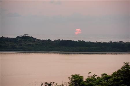 石垣島の中央に位置する伊原間地区、崖っぷちにある私の家のベランダからは林の向こうの海に朝焼けを望むことができる＝２０１５年２月１１日、沖縄県石垣市（永山真治さん撮影）