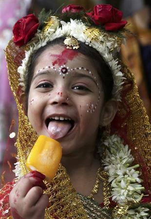 アイスクリームを食べるあどけない少女は、実は「クマリ」として人々から崇拝を集める＝２０１５年３月２８日、インド・西ベンガル州コルカタ（ＡＰ）