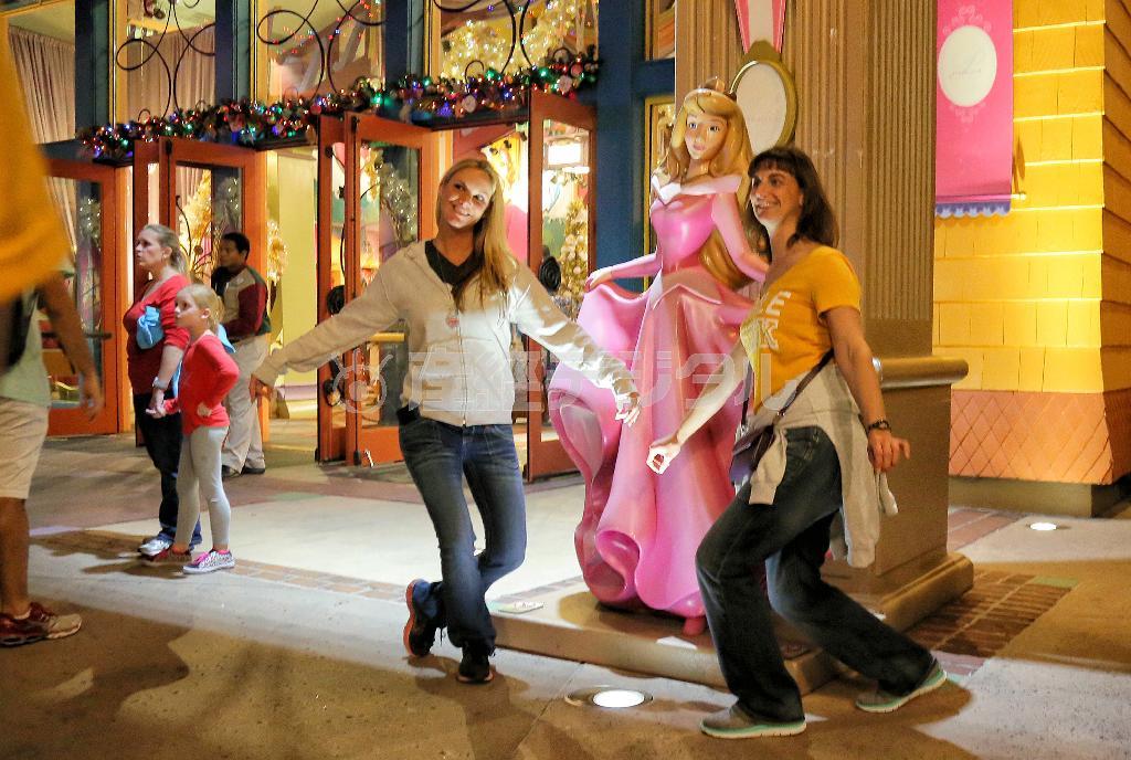 アミューズメントエリア「ダウンタウン・ディズニー」のキャラクターショップ前で、「眠れる森の美女」のヒロイン・オーロラ姫と記念写真を撮る観光客＝２０１４年１２月６日、米フロリダ州オーランド（早坂洋祐撮影）