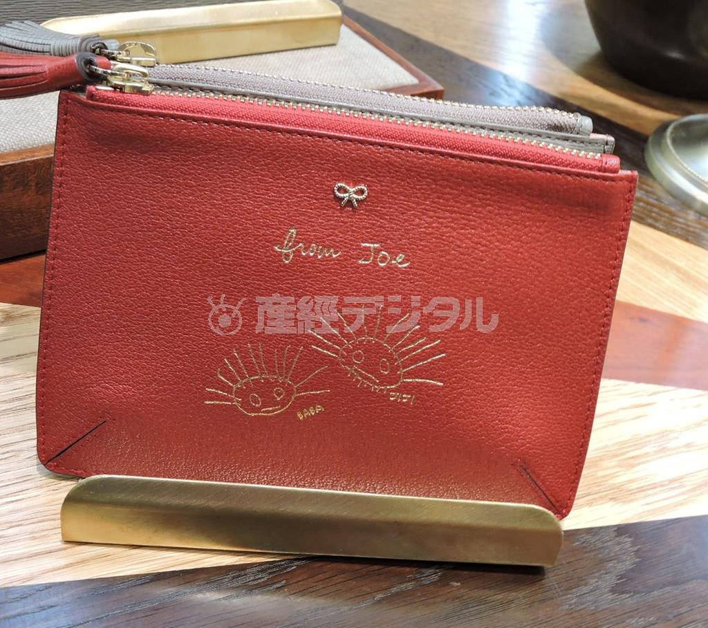 手書きのメッセージやイラスト、イニシャルが刻印できるルース・ポケットのシリーズ。写真は孫の絵を刻印した祖父母へのプレゼントとして作られた。「その瞬間に見せるかわいさをとらえたい」とアニヤ・ハインドマーチさん。シリーズは２万５０００円からで素材によって価格が異なる。刻印代は４０００円から＝２０１５年３月１８日、東京都港区（藤沢志穂子撮影）