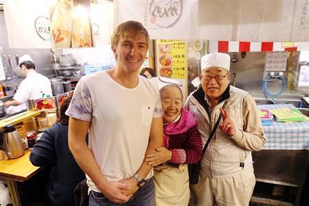 １月の築地です。冬の一番寒い時期に、カナダからやってきたという観光客が半袖で歩いているのを見て、驚いているどんぶり屋のご夫妻。３人を一緒に撮影させてもらいました。背の高い金髪の欧米人と日本のお年寄りの組み合わせは抜群に面白い被写体で、フォトジェニックだと思います＝２０１４年、東京都中央区（須藤夕子さん撮影）