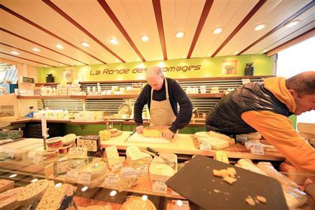 さすがフランス、チーズがたくさん売られています。ほとんどが量り売りで、このように店員さんにカットしてもらいます。チーズの名前や値段がはっきり写っている方が情報量が多く、見る人を楽しませることができます。その点を考えながら露出決定すると良いでしょう＝２０１５年３月８日（須藤夕子さん撮影）