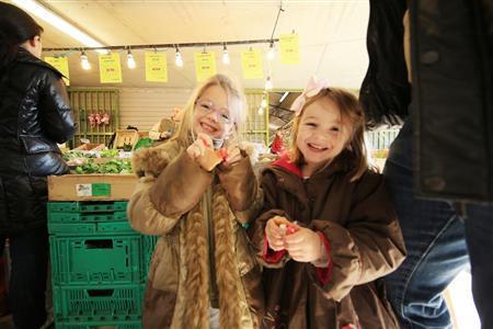 毎週このマルシェに家族でやってくるという姉妹です。日本から持って行った金魚のオモチャを渡したらとても喜んで、この笑顔を向けてくれました。子供は背が低いので市場の中では埋もれて撮りにくくいので、望遠レンズは不向きです。なるべく広い画角で撮れるズームレンズが良いでしょう。これは１１ミリ～２４ミリのズームレンズで撮影しました＝２０１５年３月８日、フランス（須藤夕子さん撮影）