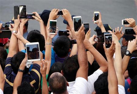 首都マニラを訪れたローマ法王をスマホで撮影しようと群がる人々。フィリピンはスマホの出荷台数が急伸している＝今年１月（ＡＰ）
