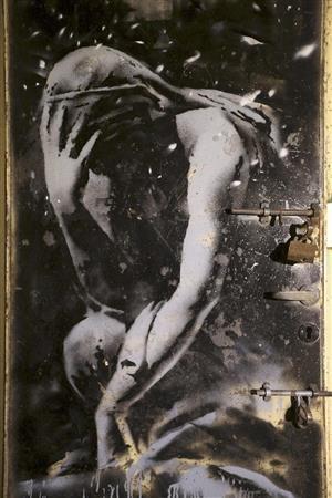 英覆面ストリートアーティスト、バンクシー氏がパレスチナ自治区ガザでイスラエル軍の空爆によって破壊された家屋のドアに描いた作品＝２０１５年３月３１日、イスラエル（ＡＰ）