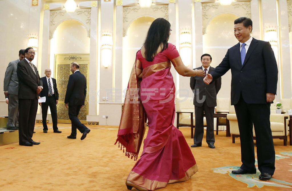 アジアインフラ投資銀行（ＡＩＩＢ）の設立式典に出席した各国代表と握手する中国の習近平国家主席（右端）。右奥は楼継偉財政相＝２０１４年１０月、中国・首都北京市西城区の人民大会堂（共同）