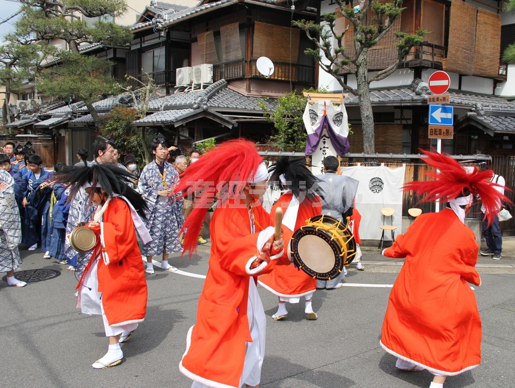 家の前で太鼓や鉦（かね）を打ち鳴らし、飛び跳ねながら舞いを披露する鬼役の少年たち＝２０１５年４月１２日、京都市北区紫野上野町（田中幸美撮影）