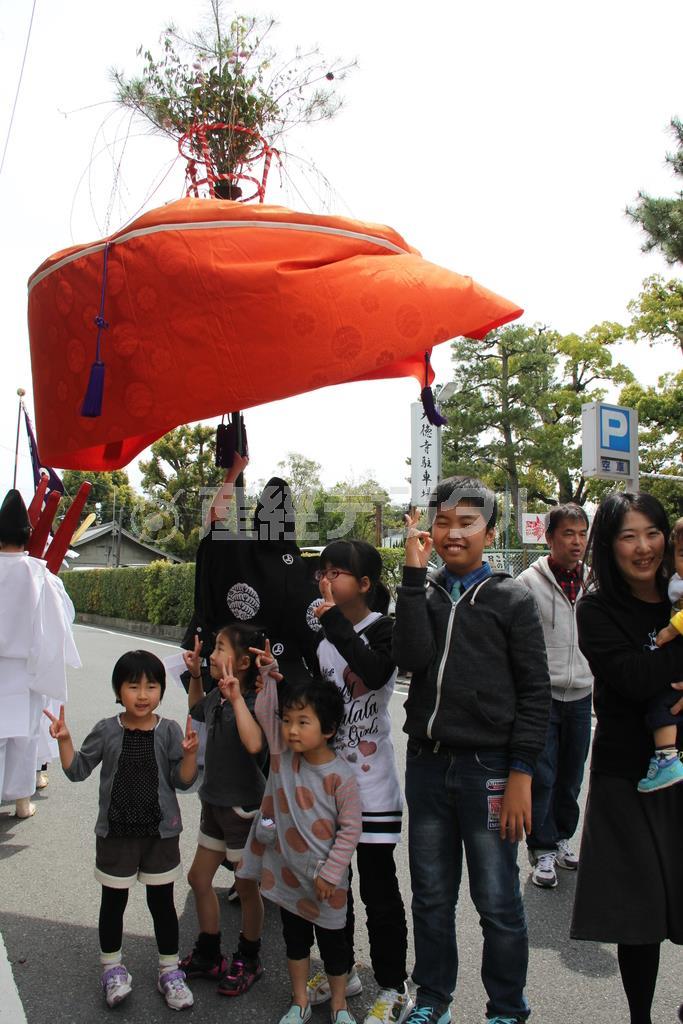 花笠の中に入ると、厄を逃れ健康に過ごせるという言い伝えから、花笠を見つけると人々はうれしそうに中に入っていた＝２０１５年４月１２日、京都市北区（田中幸美撮影）