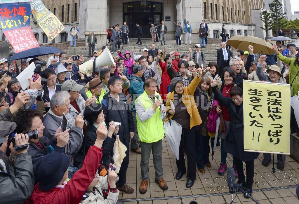 高浜原発３、４号機の再稼働差し止めの仮処分決定を受け、垂れ幕を掲げ喜ぶ申し立て住民ら＝２０１５年４月１４日午後、福井県福井市・福井地裁前（共同）