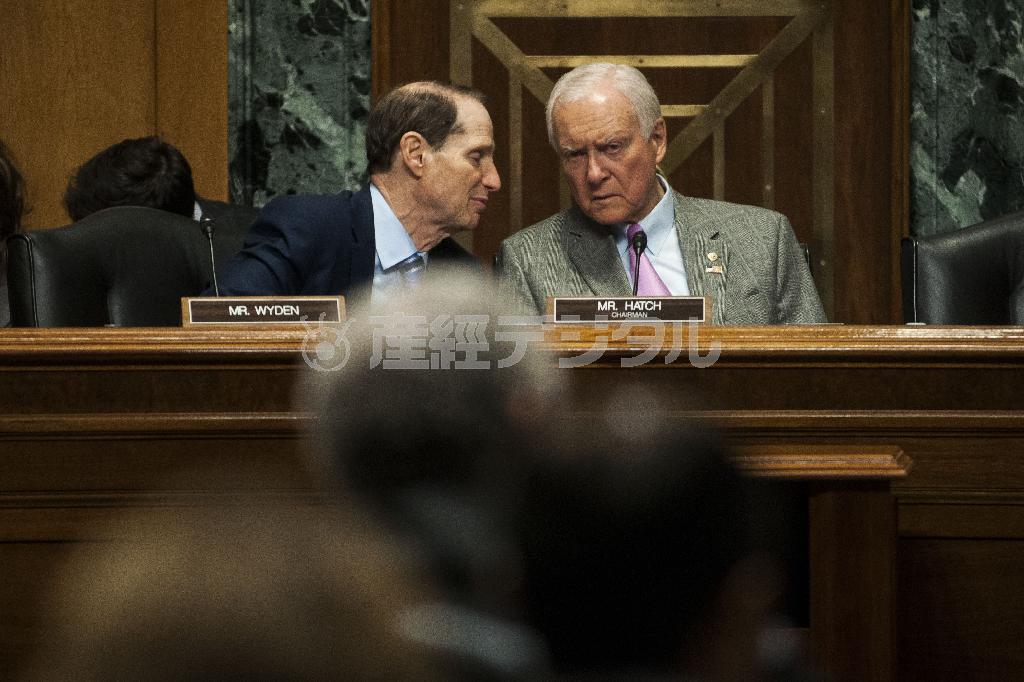 ４月１６日、米国・首都ワシントンで、言葉を交わす共和党のオリン・ハッチ上院財政委員長（右）と民主党のワイデン筆頭理事＝２０１５年（ゲッティ＝共同）