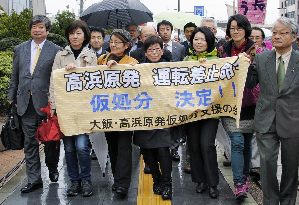 高浜原発３、４号機の再稼働差し止め仮処分の決定を前に、福井地裁に入る申し立て住民ら＝２０１５年４月１４日、福井県（共同）