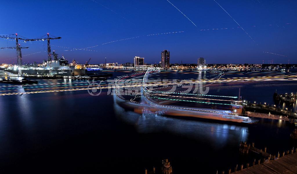 未明から明け方にかけてのノーフォーク港。軍艦が入港する造船所にはライトが灯り、連絡船が対岸のポーツマスとの間を行き交う（３０秒露光した写真５５１枚を比較明合成）＝２０１４年１１月２８日、米バージニア州ノーフォーク（早坂洋祐撮影）