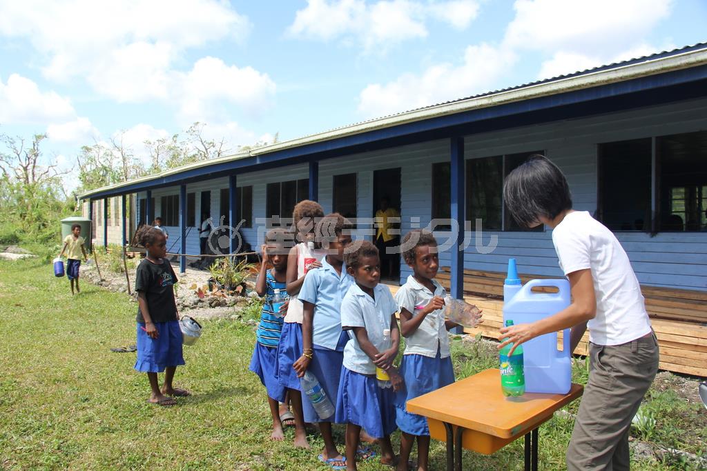 飲み水がなかったマンガリリュー小学校で水を配る相川梨絵さん（右）＝２０１５年４月２日、バヌアツ（相川梨絵さん提供）