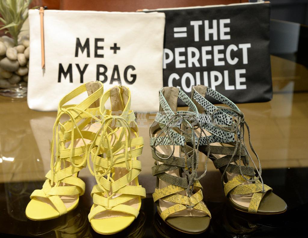 革の空押しサンダル（１万８０００円）とクラッチバッグ（後方、４９００円）。書かれているフレーズは「あなたと私（＝バッグ）は相性ピッタリ」＝２０１５年４月１０日、東京都港区（寺河内美奈撮影）