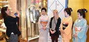 三越銀座店の「金沢・能登・加賀展」をＰＲする金沢芸妓らと記念写真を撮る外国人客＝２２日、東京都中央区