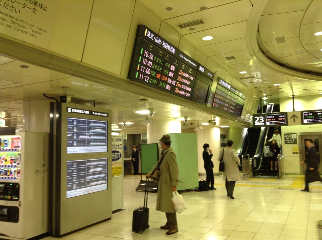 ＪＲ東日本側の東京駅新幹線改札内。大きな発車案内ボードのほかにも、絵による列車説明、エスカレーター乗り場の頭上のパネルと、案内でいっぱい＝ＪＲ東京駅