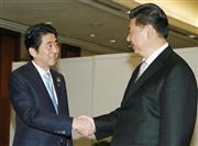 会談を前に握手する安倍晋三（しんぞう）首相（左）と中国の習近平国家主席＝２０１５年４月２２日、インドネシア・首都ジャカルタ（共同）