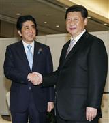 会談を前に握手する安倍晋三首相（左）と中国の習近平国家主席＝２２日、ジャカルタ（共同）